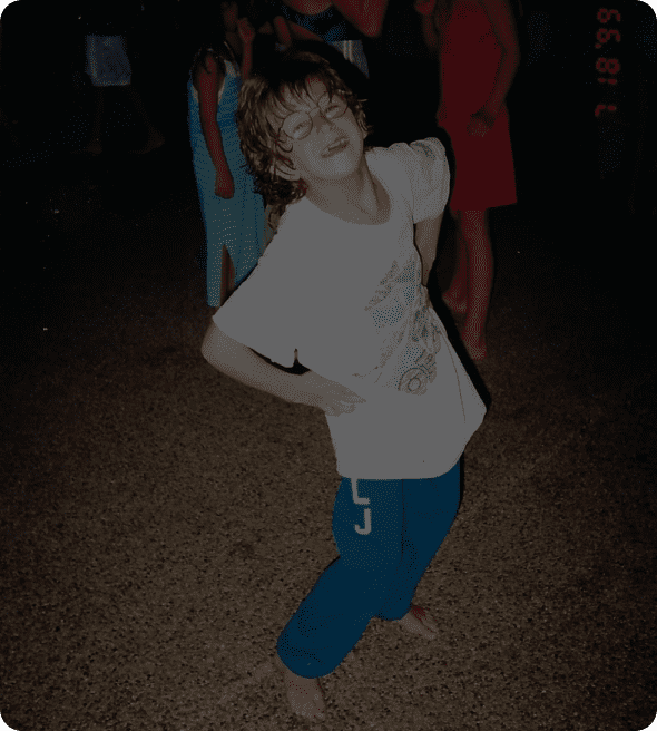A young child posing playfully with hands on hips.